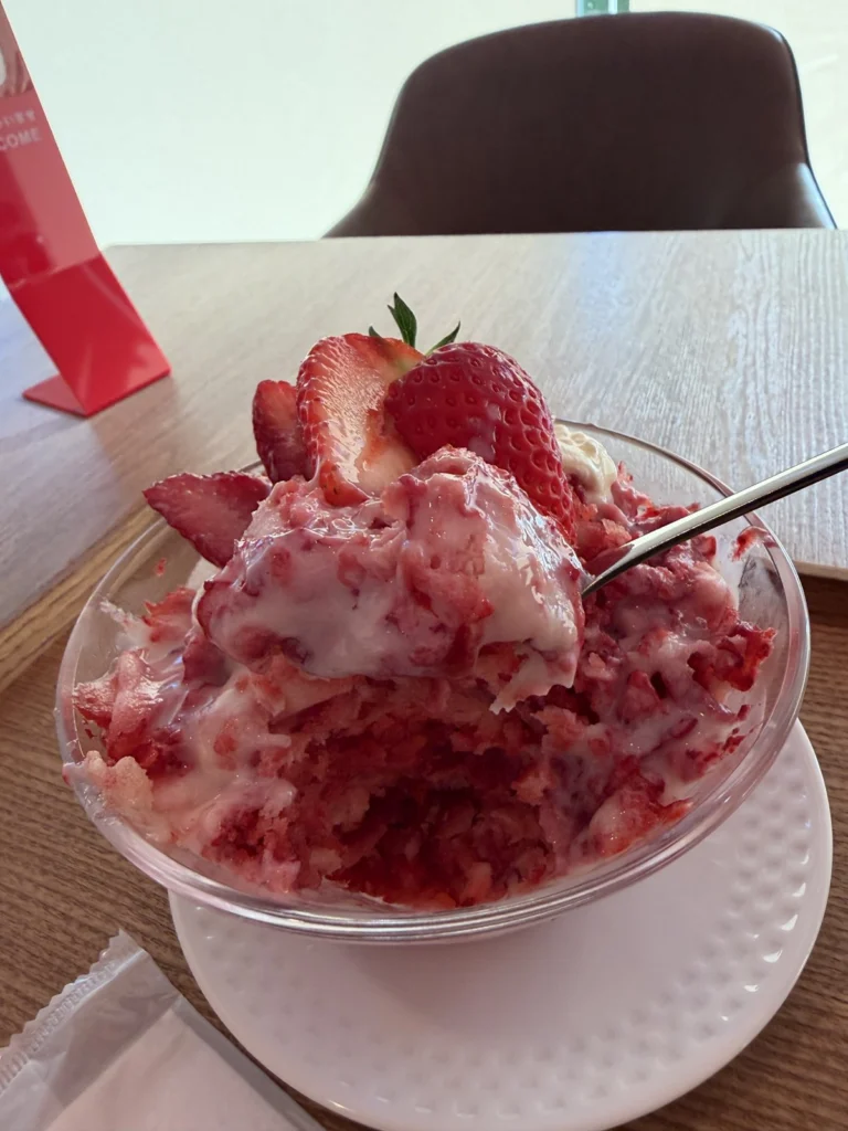 いちごの削り氷に白いソースとクリームがかかった削りいちご