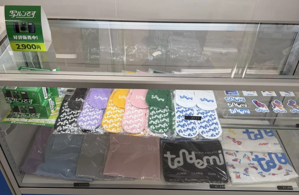 トンデミショップのショーケース。ロゴ柄のソックス450円、写ルンです2,900円、Tシャツ2,200円の札